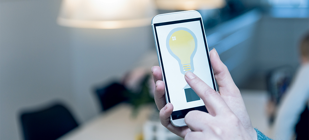 A man turns on the light using a mobile app.