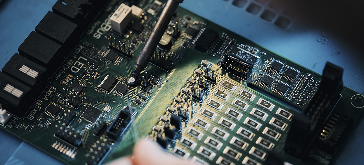 An electronics engineer is soldering an integrated circuit to a printed circuit board.