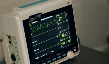 The monitor of a medical electronic device with vitals on the screen.