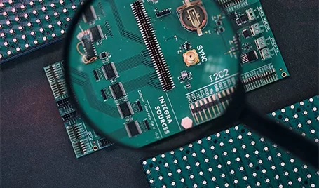 A printed circuit board under a magnifying glass.
