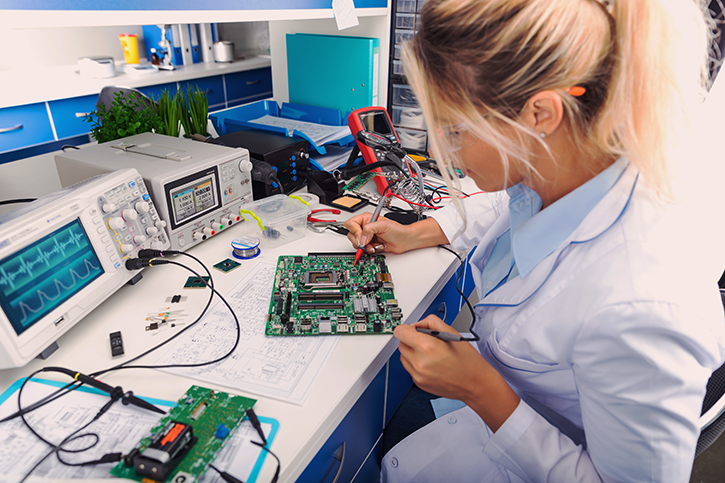 A specialist checks a circuit board in a laboratory.