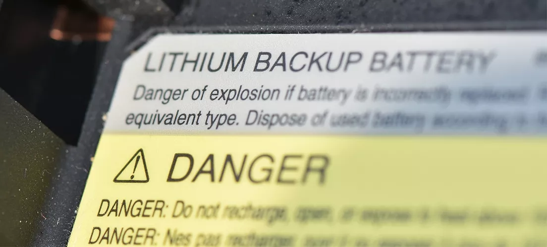 A label on a lithium backup battery warning about dangers.