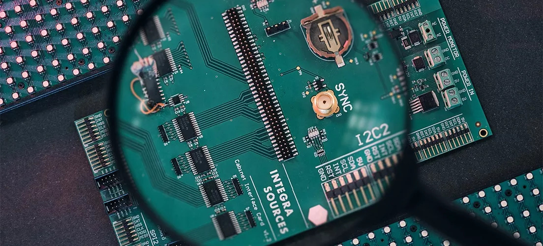 A printed circuit board under a magnifying glass.