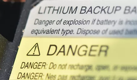 A label on a lithium backup battery warning about dangers.