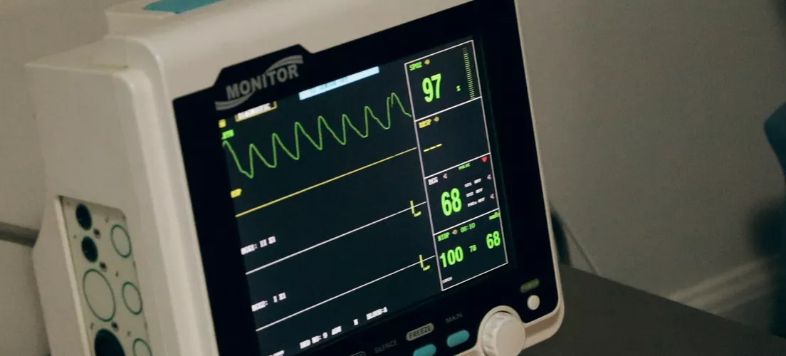 The monitor of a medical electronic device with vitals on the screen.